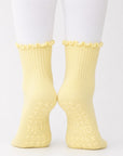 Butter yellow ribbed crew grip socks worn with white leggings, back view with grip soles