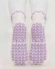 Non-slip soles of lavender bow grip socks with purple bow-shaped grips and almla logo