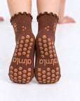 Back view of The Doodle Grip Sock worn on both feet, showing the full paw-print grip pattern and Almla logo on the soles