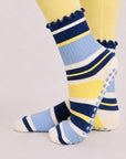 Navy and yellow striped pilates grip socks worn with butter yellow leggings, side view