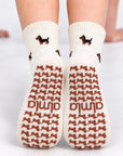 Back view of The Dachshund Grip Sock worn on both feet, showing the all-over dachshund print and dachshund-shaped grip soles with the Almla logo