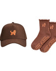 The Goldendoodle Set, an espresso brown goldendoodle hat with matching brown Doodle grip socks with ruffle cuffs and tan paw print grips