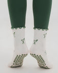 Martini print crew grip socks worn with green leggings, back view with grip soles showing