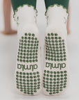 Non-slip soles of martini grip socks with green silicone grip dots and almla logo