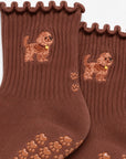 Close-up of The Doodle Grip Sock detailing the embroidered golden doodle design, ruffle cuff, and paw-shaped non-slip grip soles