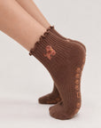 Model wearing The Doodle Grip Sock on pointed toes, side profile showing the paw-print grip soles and embroidered golden doodle