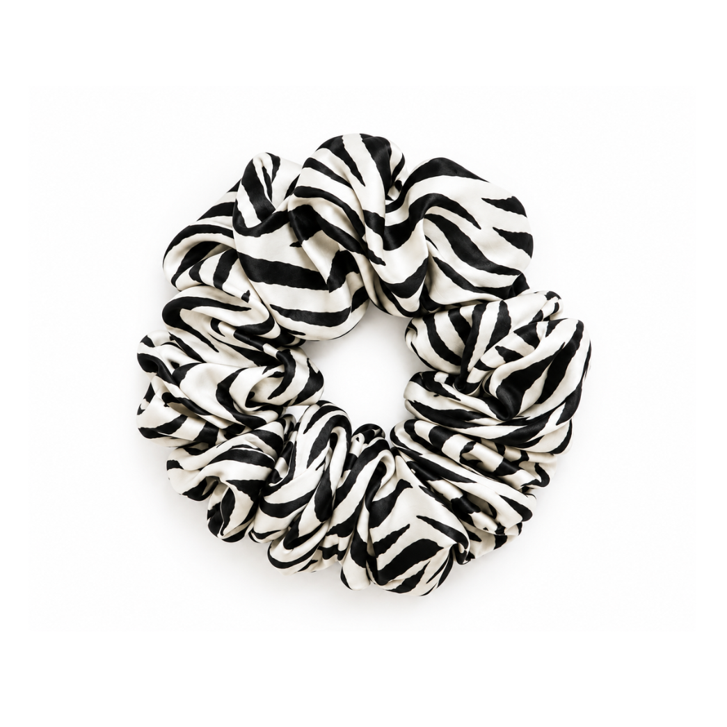 The Zebra Silk Scrunchie, 100% mulberry silk in a black and white zebra animal print, gentle on hair and matching the Zebra Pilates grip socks