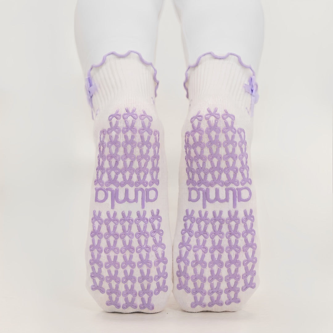 Non-slip soles of lavender bow grip socks with purple bow-shaped grips and almla logo