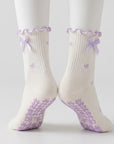 Bow print crew grip socks with lavender ribbon ties, back view with grip soles showing
