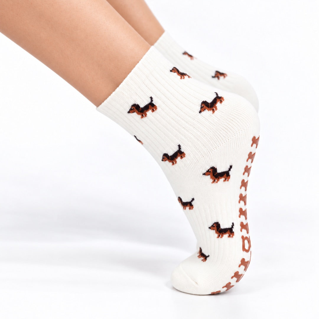 Model wearing The Dachshund Grip Sock on pointed toes, side profile showing the dachshund print and grip soles