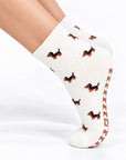 Model wearing The Dachshund Grip Sock on pointed toes, side profile showing the dachshund print and grip soles