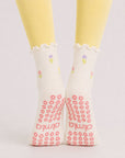 Flower print crew grip socks worn with yellow leggings, back view with grip soles showing