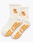 The Orange Cat Grip Sock in cream with an embroidered orange tabby cat, ruffle cuff, and paw-shaped non-slip grips, laid flat on a white background