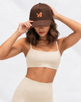 Woman in cream activewear wearing the Goldendoodle Brown Hat from the Goldendoodle Set