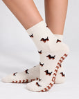 Model wearing The Dachshund Grip Sock, crossed feet showing the all-over dachshund print and dachshund-shaped grip soles