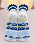 Blue and yellow grip sock soles seen from behind, full grip pad and almla logo visible