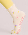 Woman in a plank position wearing floral grip socks, pink flower grips visible on the sole