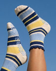 Navy, blue and yellow striped crew grip socks with legs up against a blue sky