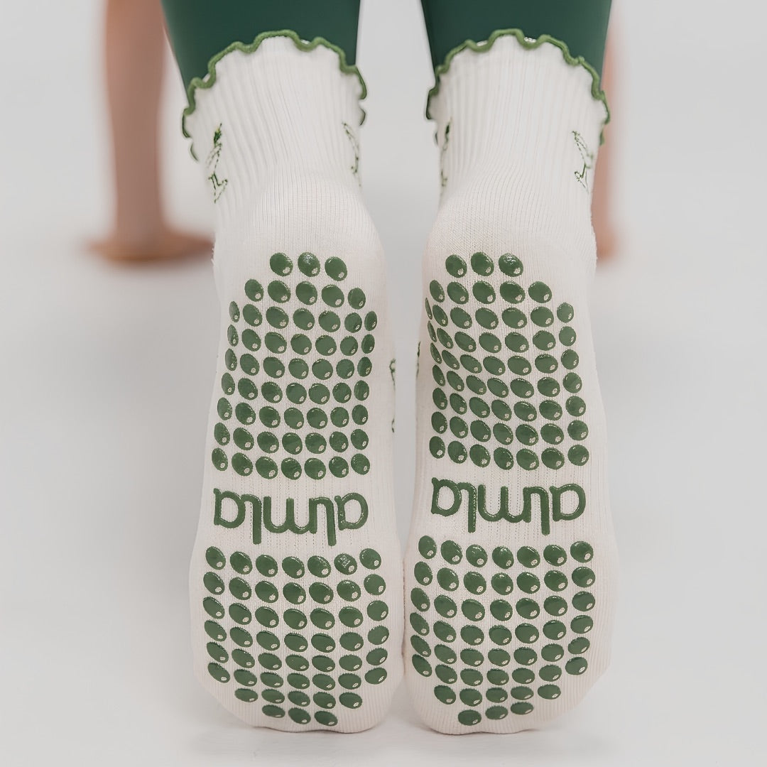 Non-slip soles of martini grip socks with green silicone grip dots and almla logo