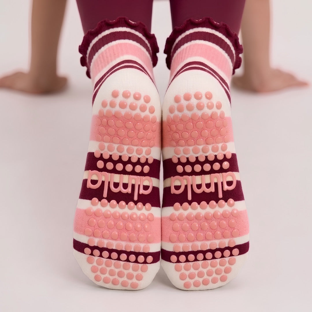 Non-slip soles of raspberry cream grip socks with silicone grip dots and almla logo