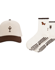 Flat lay of a cream espresso-martini cap beside white cute pilates grip socks with brown coffee-bean grip soles.