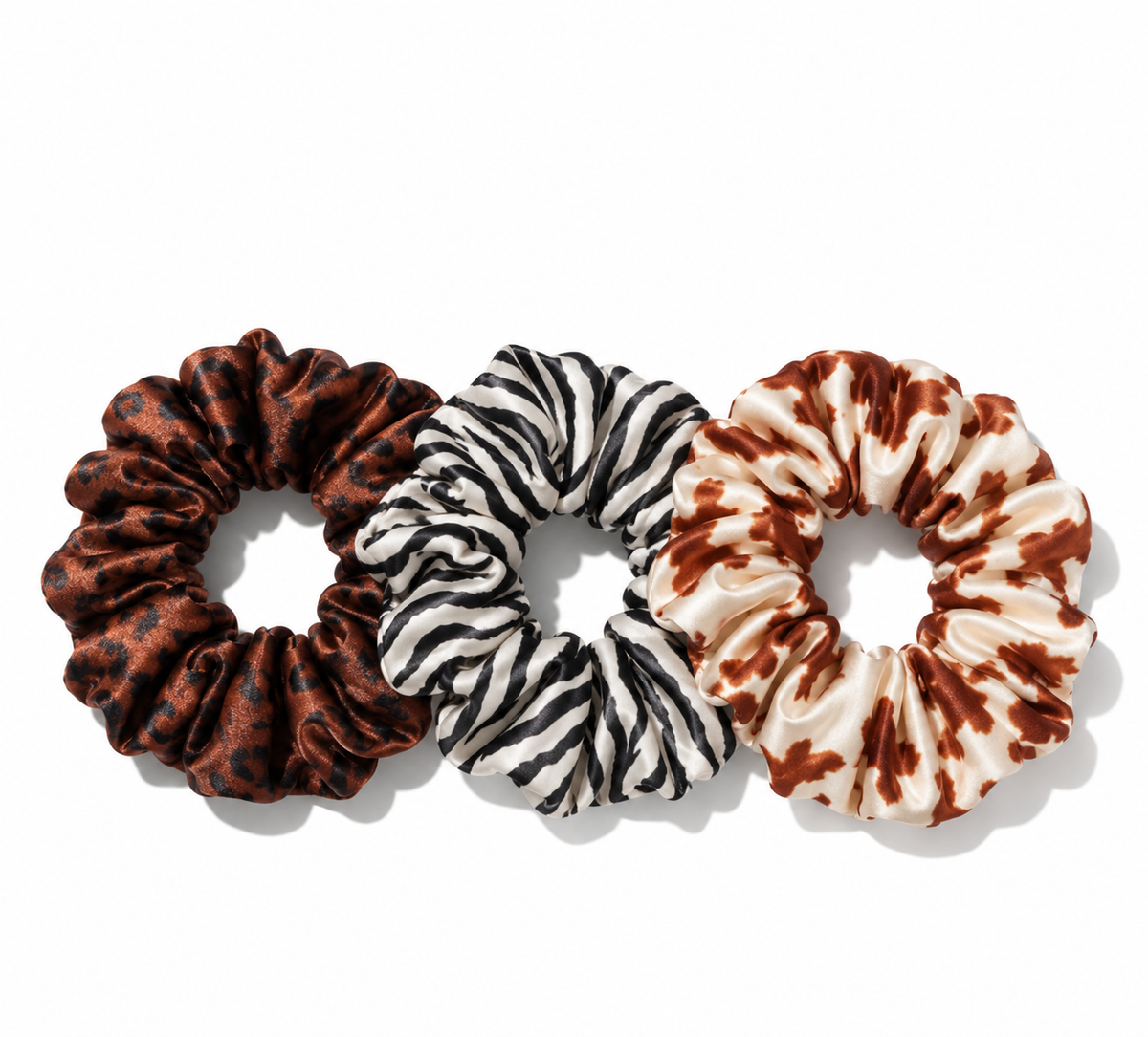 The Animal Print Silk Scrunchie 3-Pack, set of three mulberry silk scrunchies in zebra, cowhide, and leopard prints