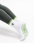 White sock with green accents worn by a person on a white background