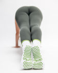 Person wearing green leggings and white socks with green dots on a white background