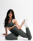 Woman in gray athletic wear posing on a white background